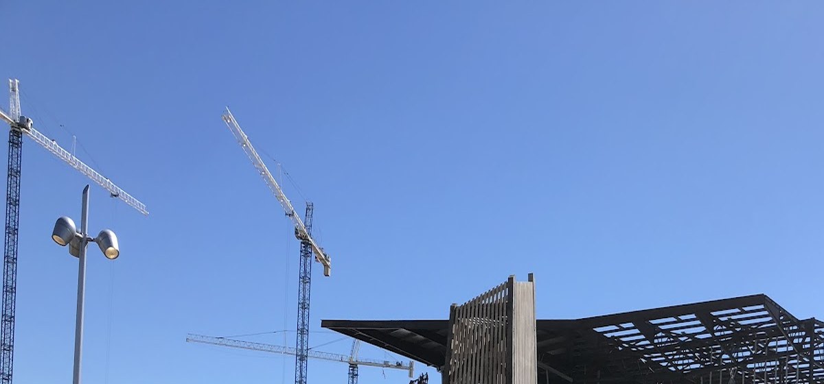 Active concrete placement at a steel-frame construction site.